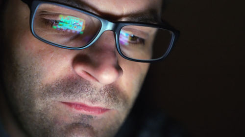 Close-up of man wearing eyeglasses with reflection