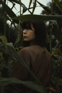 Portrait of young woman looking at plants