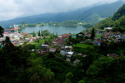 High angle view of townscape by mountains against sky