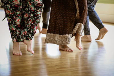 Low section of women standing on hardwood floor