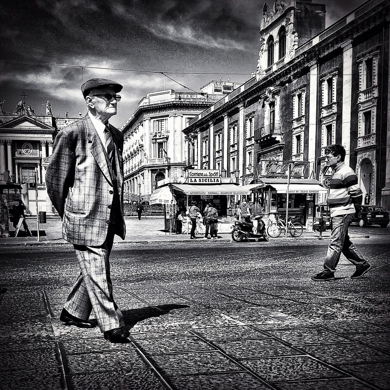 building exterior, architecture, built structure, street, city, men, city life, building, cobblestone, person, walking, lifestyles, sky, incidental people, outdoors, town square, residential structure, residential building, street light