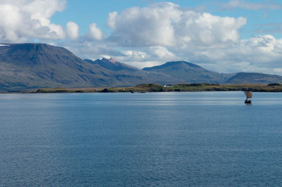 Scenic view of lake by mountains against sky