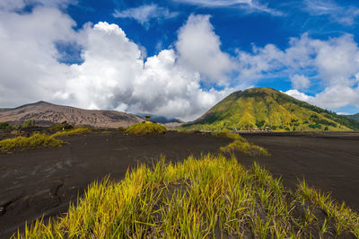 Scenic view of land and mountains against sky