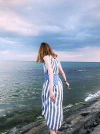 Woman looking at sea against sky