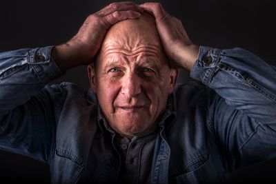 Portrait of man against black background