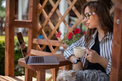 Woman using mobile phone while sitting at home