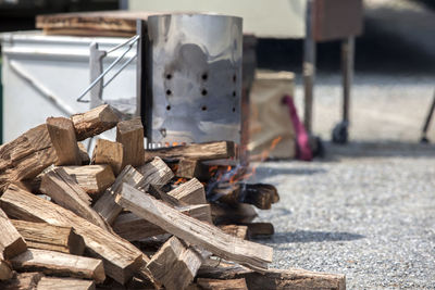 Close-up of firewood by camping stove on field during camping