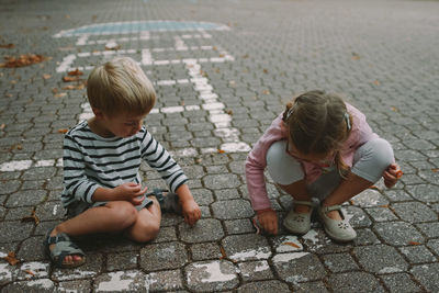 High angle view of boy playing on cobblestone