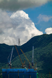 Cranes at construction site against sky