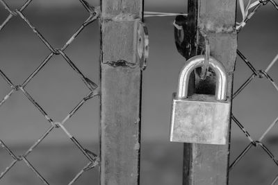 Close-up of padlock on chainlink fence