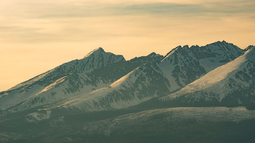 Scenic view of snowcapped mountains against sky during sunset