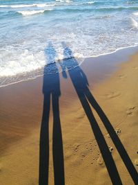 Shadow of man and woman standing on beach