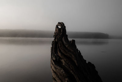 Rock formation in sea against sky