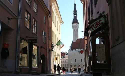 People walking on street amidst buildings in city