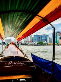 Close-up of boat in city against sky