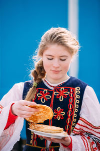 Young woman holding ice cream outdoors