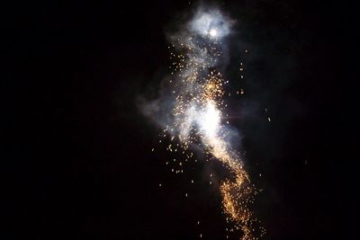 Low angle view of firework display at night