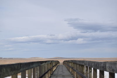 Bridge over calm sea against sky