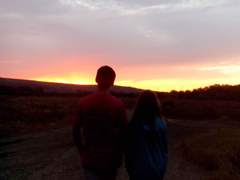 Rear view of man and woman at sunset