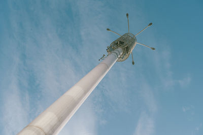 Low angle view of communications tower against blue sky