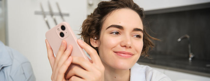 Portrait of young woman using phone