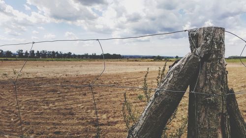 Wooden fence on field against sky