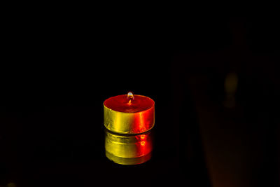 Close-up of illuminated candle against black background