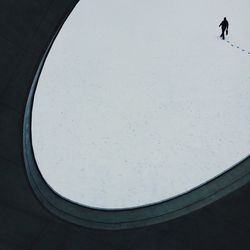 High angle view of man walking on snow seen from window