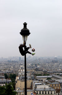 Man hanging on street light