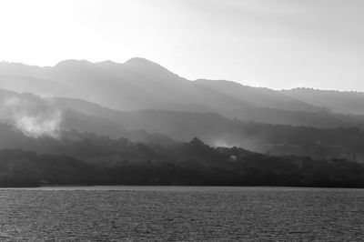 Scenic view of sea and mountains against sky