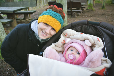 Portrait of smiling mother and baby at park