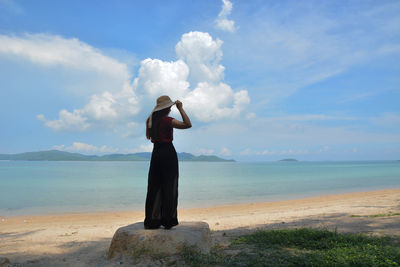 Rear view of woman standing on beach