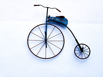 Bicycle parked on snow covered wall