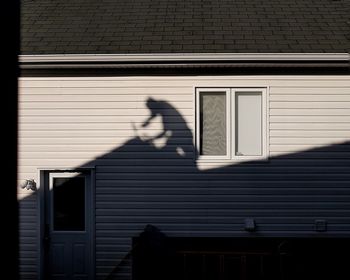 Shadow of person walking by window on building