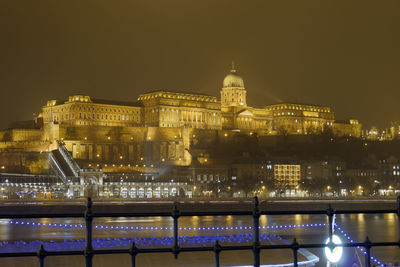 Illuminated city against sky at night