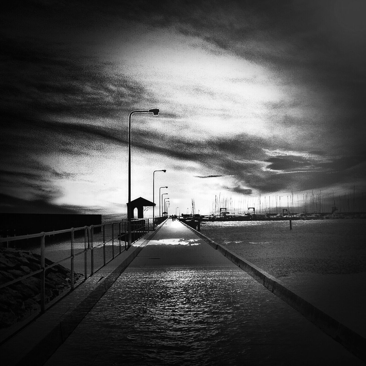 the way forward, sky, diminishing perspective, built structure, water, vanishing point, architecture, cloud - sky, street light, weather, cloudy, long, overcast, road, empty, sea, railing, transportation, connection, building exterior