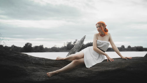 Young woman sitting on rock