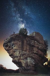 Low angle view of rock formation against sky at night