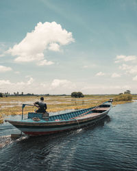 Man on boat in sea against sky