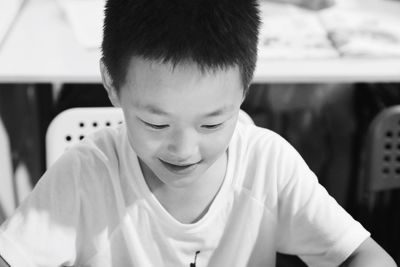 Close-up of boy smiling while sitting on chair in classroom