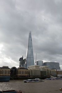 View of buildings in city against cloudy sky