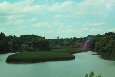 Scenic view of river against cloudy sky