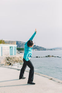 Full length of man standing on beach against clear sky