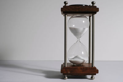 Close-up of clock on table against wall