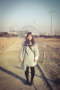 Portrait of young woman in park during sunset