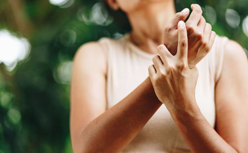 Midsection of man holding woman outdoors