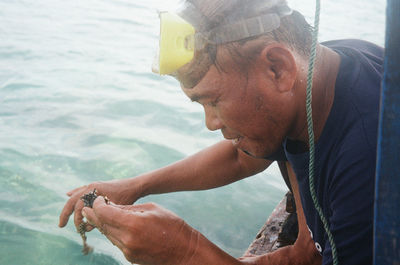 Portrait of young man holding sea