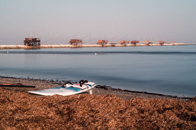 Boat moored on beach against sky