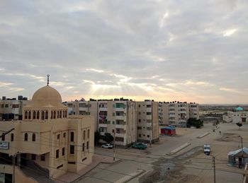 High angle view of buildings against cloudy sky