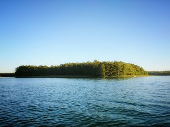 Scenic view of lake against clear blue sky
